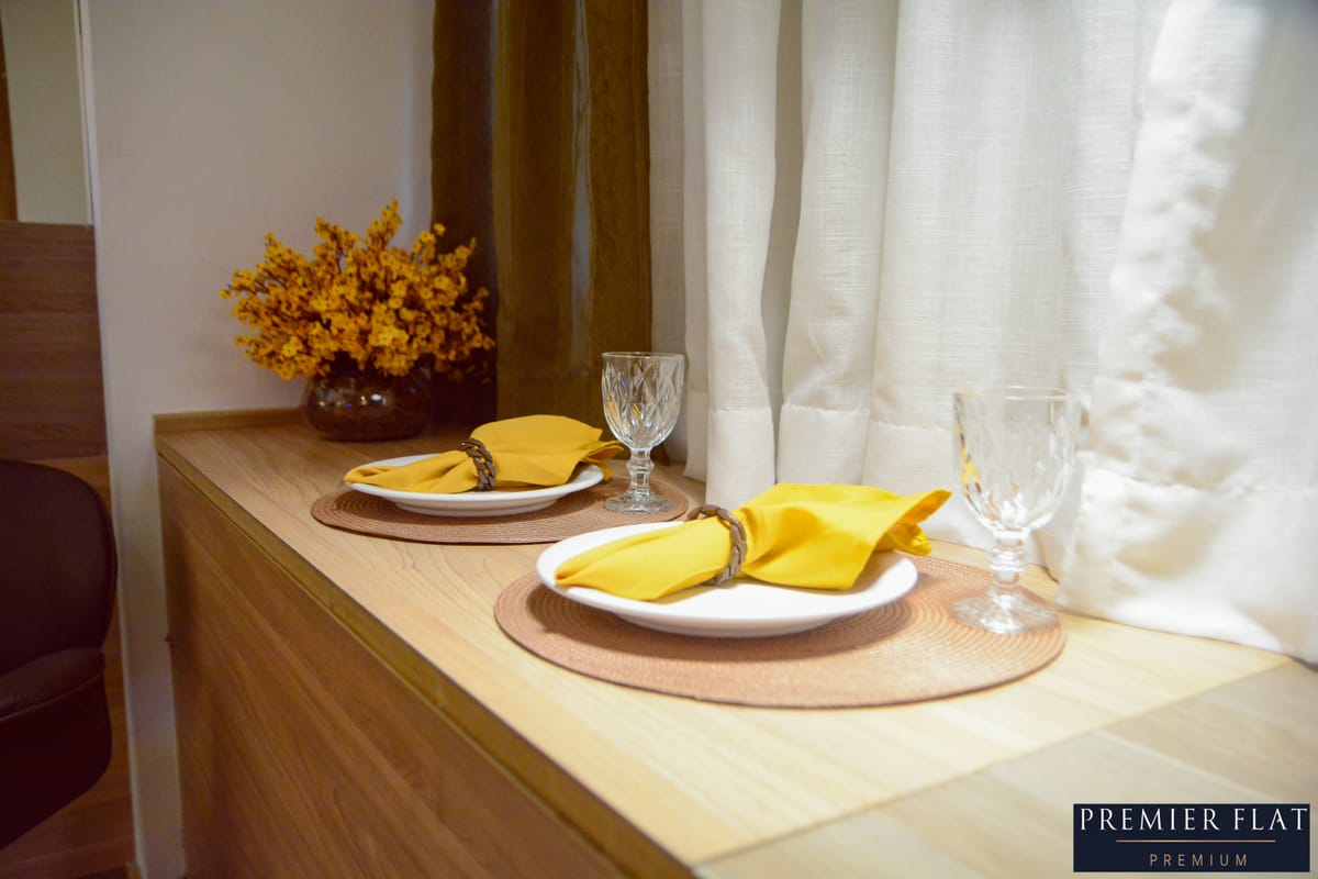 Balcão com mesa posta e vista da janela do flat