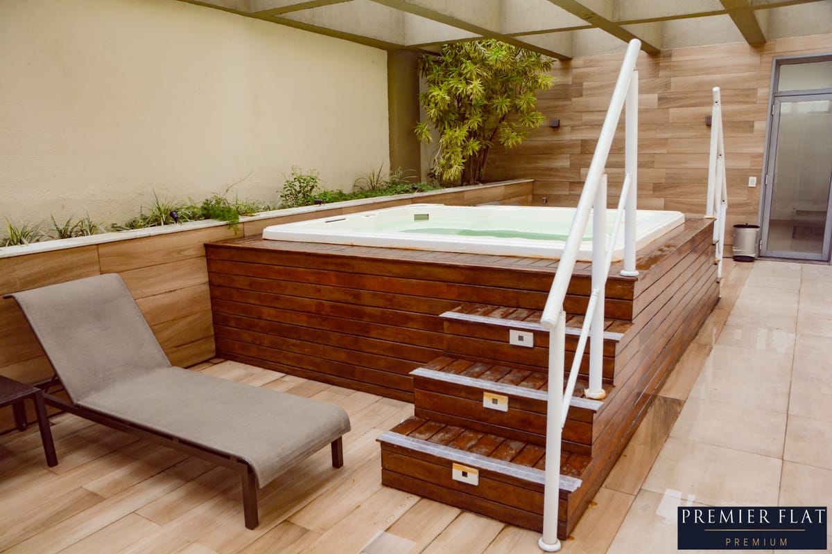 Jacuzzi com deck de madeira, espreguiçadeira e plantas