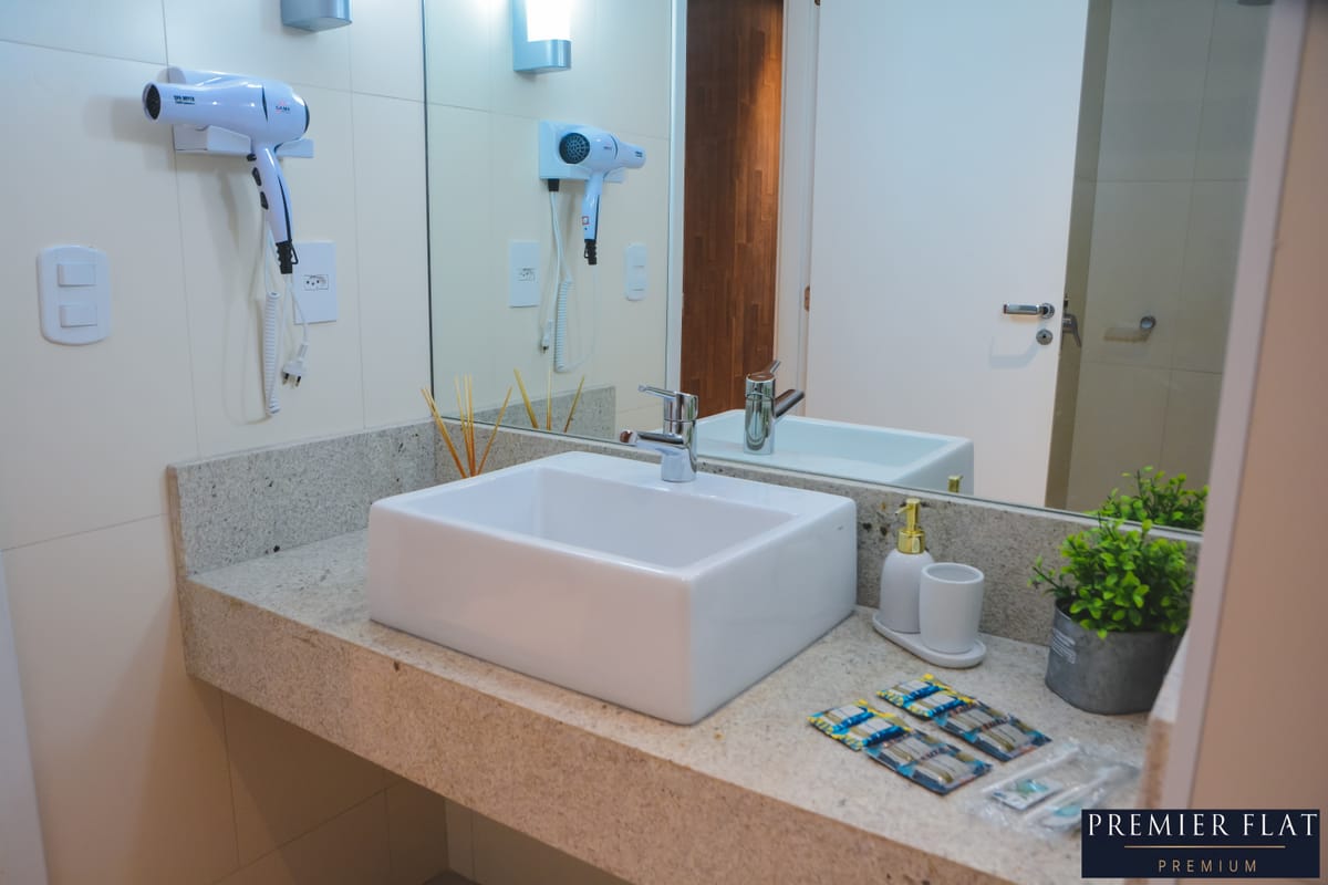 Pia do banheiro com bancada em mármore e espelho amplo