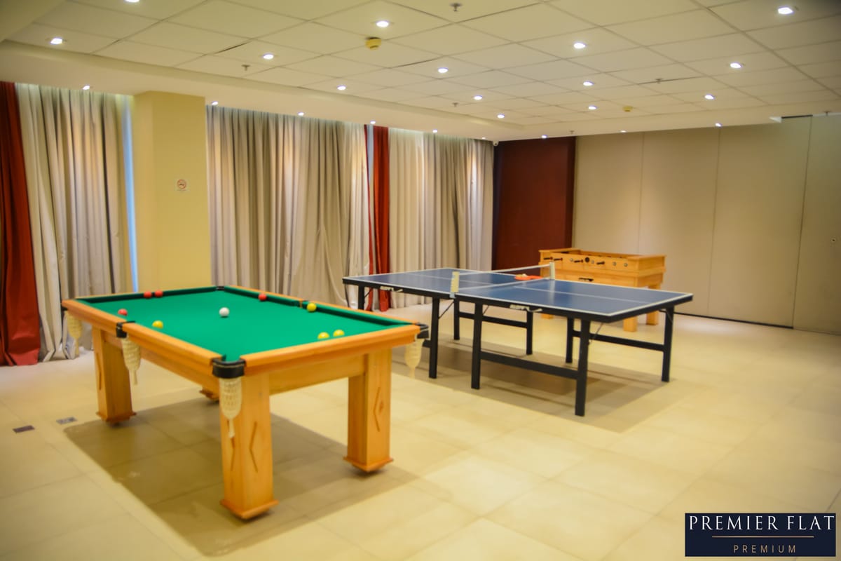 Sala de jogos com mesa de sinuca e tênis de mesa